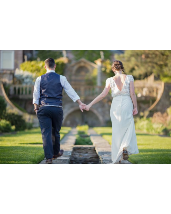 wedding couple holding hands in grand garden